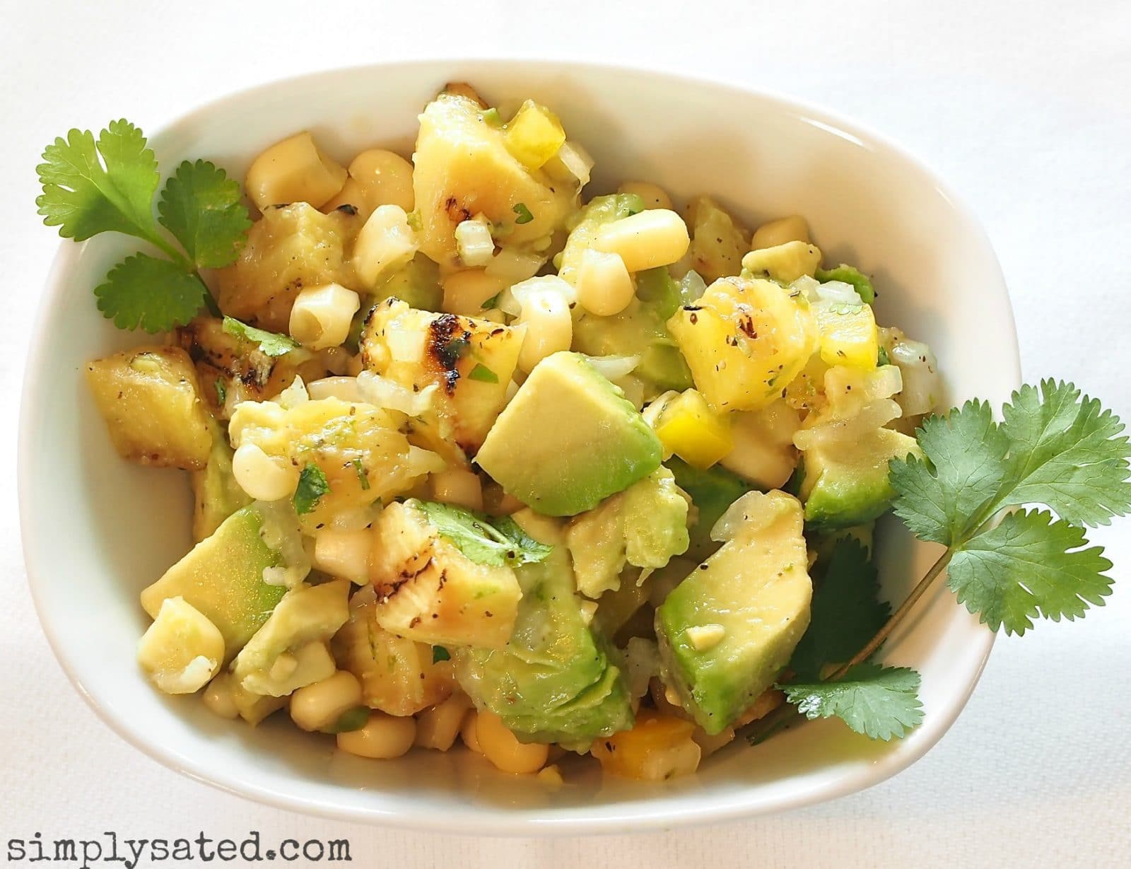 Grilled PIneapple, Avocado & Corn Salad is delicious served as a salad or salsa. The perfect pairing of flavors and so beautiful. www.simplysated.com