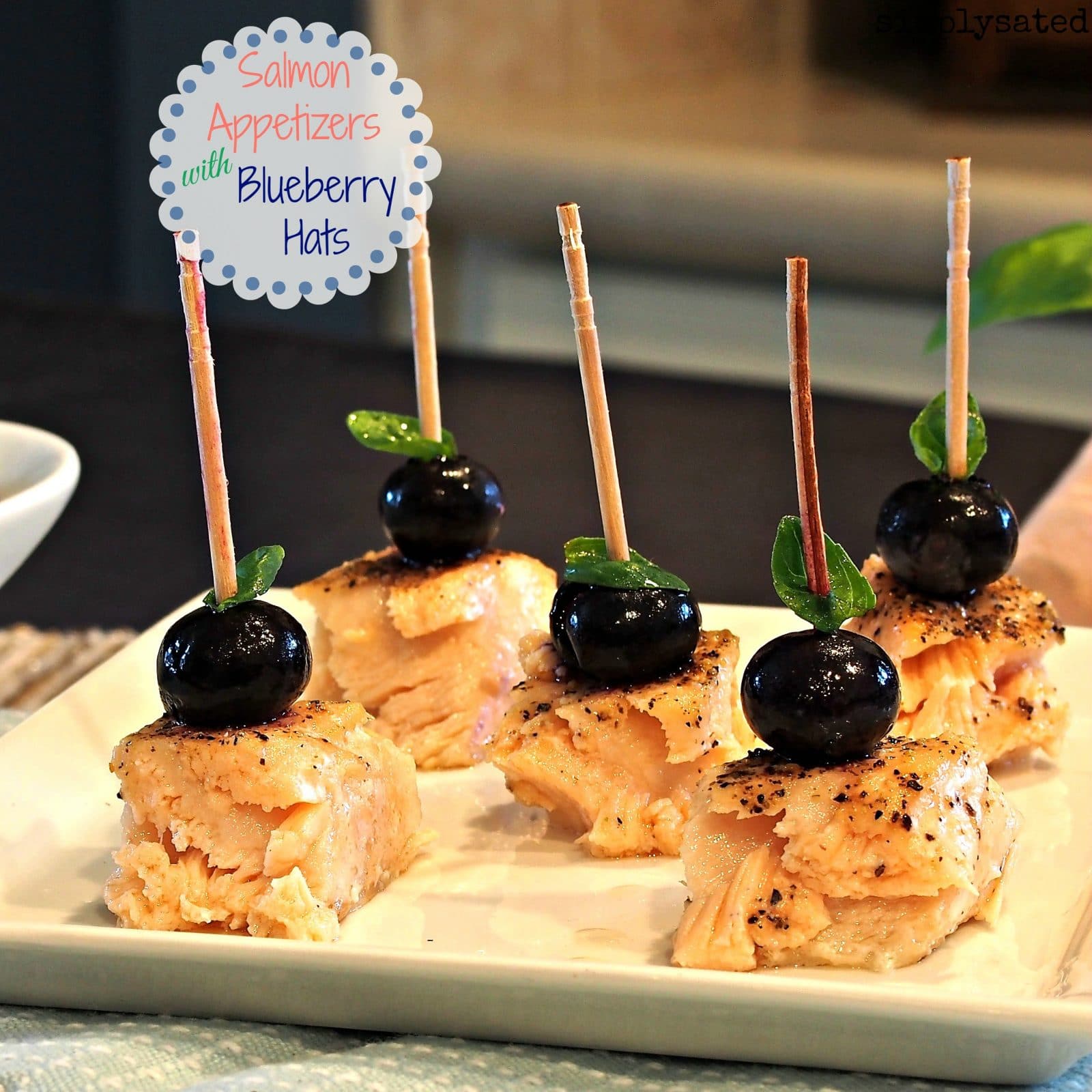 Salmon Appetizers with Blueberry Hats are beautifully simple. Baked salmon bites topped with a blueberry and basil.