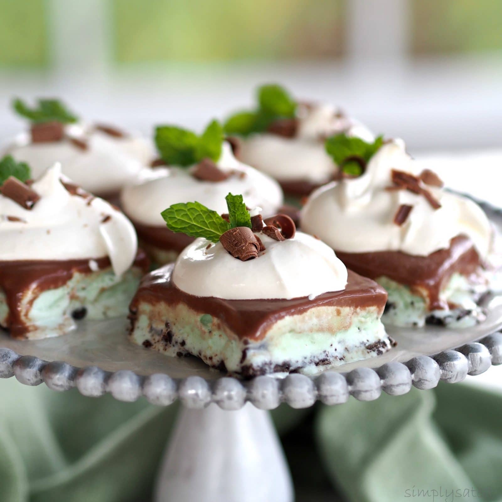 Frozen Mint Chocolate Dessert-a perfect last course for a dinner party or family dinner. Oreo crust layered with mint chocolate ice cream & whipped topping. Simply Sated