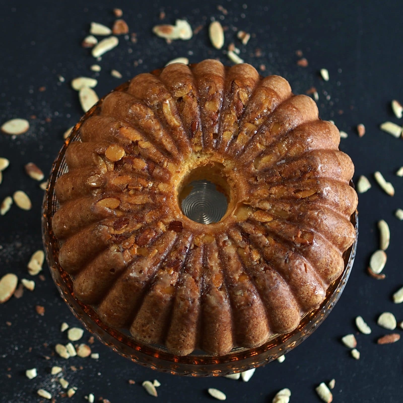 Amazing Amaretto Pound Cake - three-almond pound cake drizzled with Amaretto Glaze and topped with toasted almonds. Perfection! Simply Sated