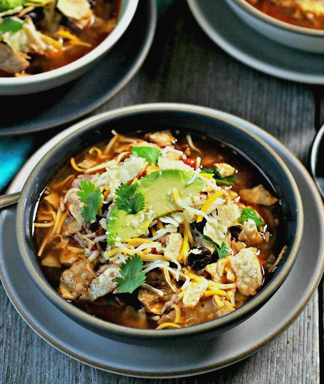 Chicken Tortilla Soup - chicken, beans, tomatoes and Mexican spices simmered together and topped with tortilla chips, cheese & sour cream. So delicious! Simply Sated