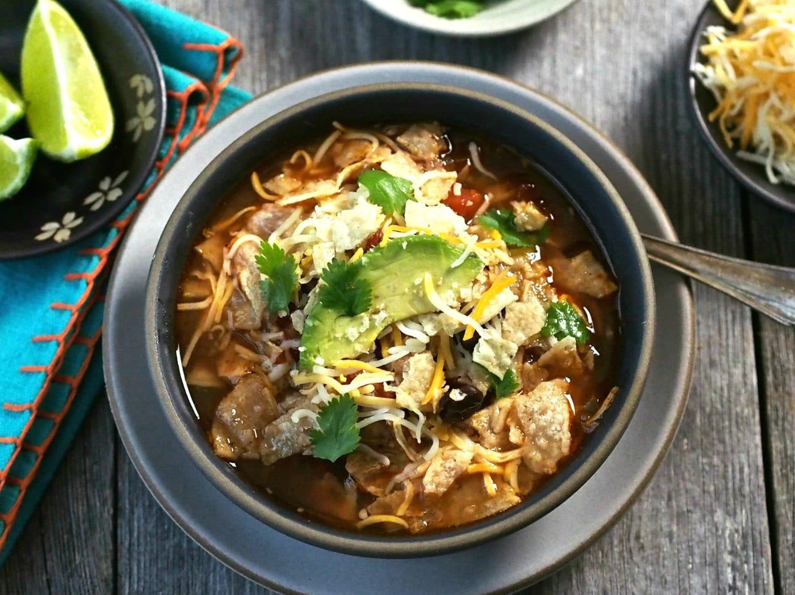 Chicken Tortilla Soup - chicken, beans, tomatoes and Mexican spices simmered together and topped with tortilla chips, cheese & sour cream. So delicious! Simply Sated