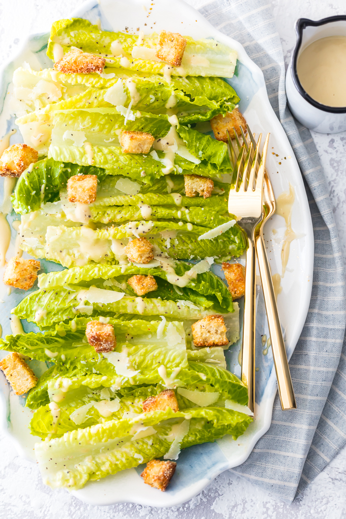 Classic Caesar Salad - there is so much to love. Crispy and leafy romaine lettuce, freshly shredded Parmigiano-Reggiano cheese & freshly ground black pepper, Homemade Garlic Parmesan Croutons drizzled with a creamy, umami-flavored dressing. This is the ultimate Classic Caesar Salad. Simply Sated