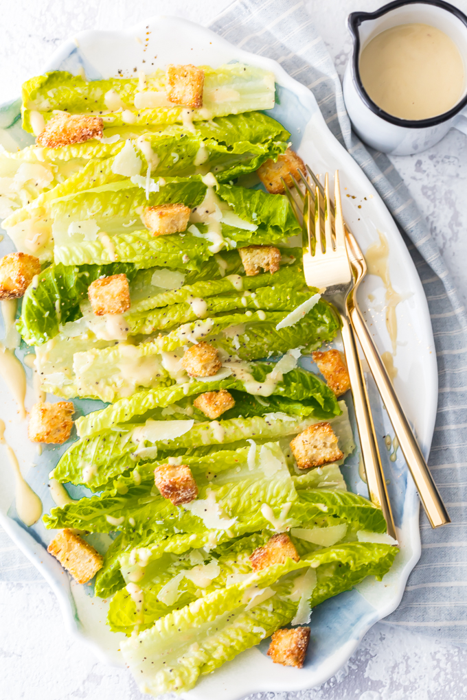 Classic Caesar Salad - there is so much to love. Crispy and leafy romaine lettuce, freshly shredded Parmigiano-Reggiano cheese & freshly ground black pepper, Homemade Garlic Parmesan Croutons drizzled with a creamy, umami-flavored dressing. This is the ultimate Classic Caesar Salad. Simply Sated