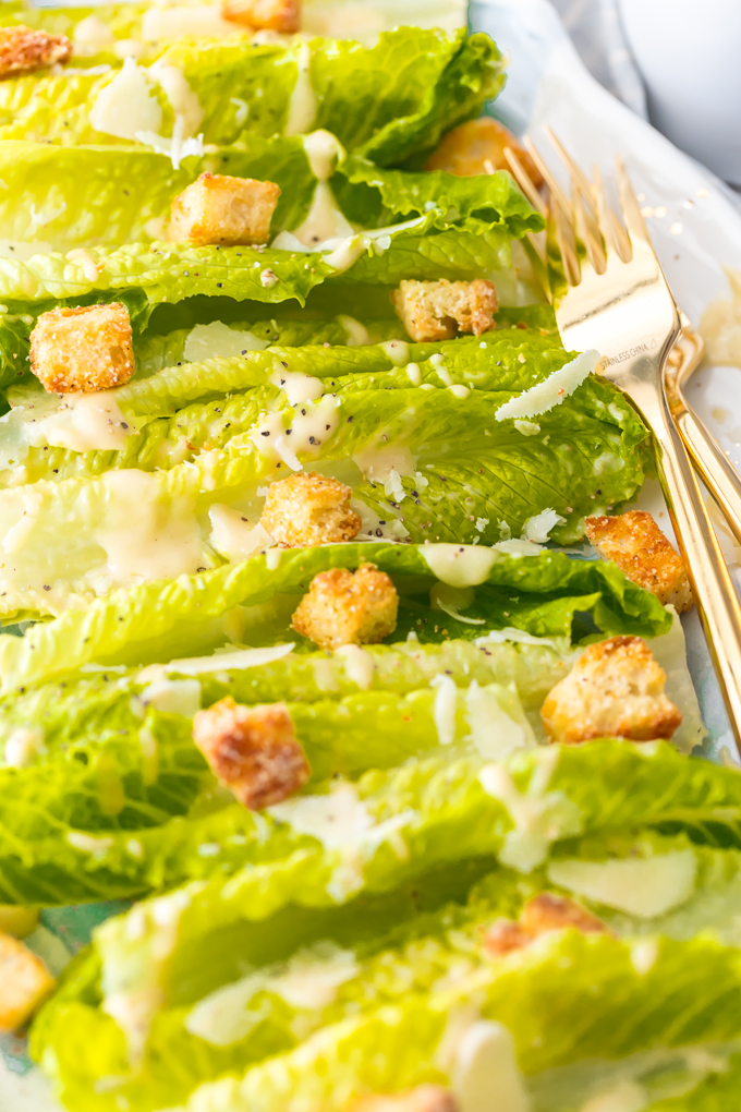 Classic Caesar Salad - there is so much to love. Crispy and leafy romaine lettuce, freshly shredded Parmigiano-Reggiano cheese & freshly ground black pepper, Homemade Garlic Parmesan Croutons drizzled with a creamy, umami-flavored dressing. This is the ultimate Classic Caesar Salad. Simply Sated